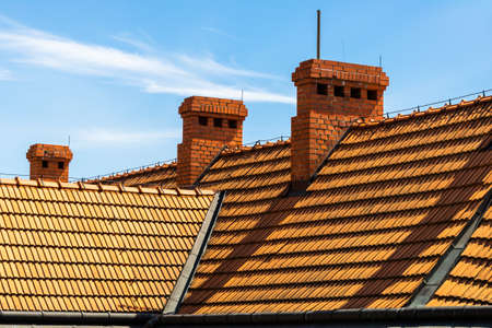 orange roof and chimneys against the background of blue sky