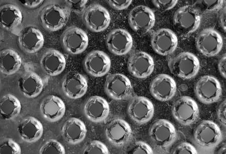 Background or texture from a gray and monophonic metal surface with symmetric and round openings.の写真素材