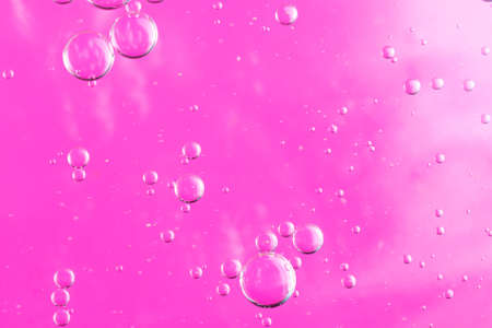 oil drops on water on a pink backgroundの写真素材