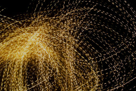 golden dashed lines of lights on black backgroundの写真素材