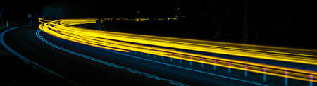 abstract blue and yellow car lights at nightの写真素材
