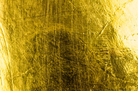 a sheet of paper painted with gold paint. background or textureの写真素材