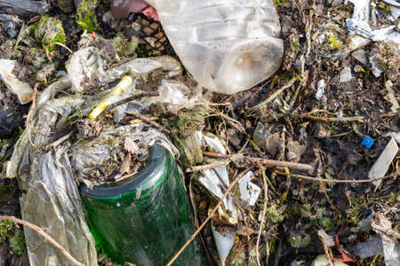 wild garbage dump. residual glass, plastics in the forest