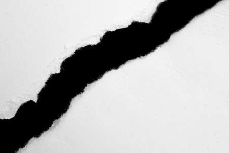 a white piece of paper on a black isolated backgroundの写真素材