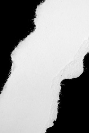 a white piece of paper on a black isolated backgroundの写真素材