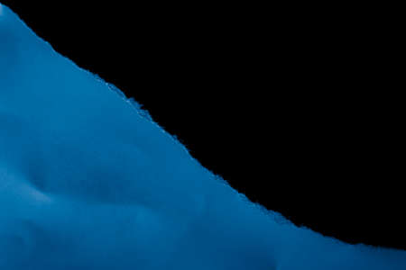 blue piece of paper on black isolated backgroundの写真素材