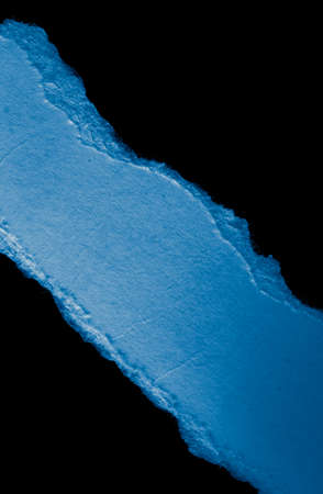 blue piece of paper on black isolated backgroundの写真素材