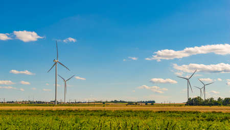 Wind power plants on the background of half and blue skyの写真素材