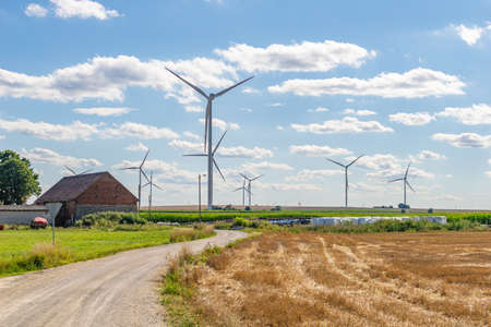 Wind power plants on the background of half and blue skyの写真素材
