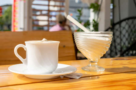 white coffee in a cup on a brown tableの写真素材