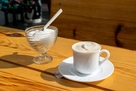 white coffee in a cup on a brown table