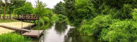a pier and a green forest on the riverの写真素材