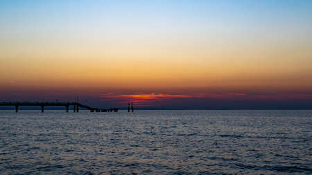 the setting sun against the backdrop of a calm seaの写真素材