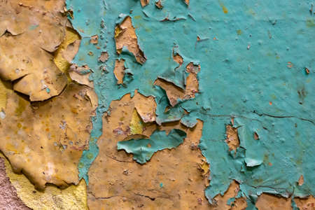 old wall with orange and blue paint peeling off. background or textureの写真素材