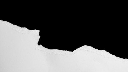 a white piece of paper on a black isolated backgroundの写真素材