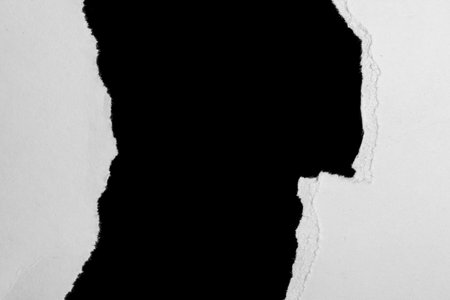 a white piece of paper on a black isolated backgroundの写真素材