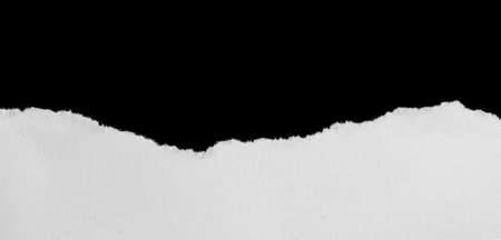 a white piece of paper on a black isolated backgroundの写真素材