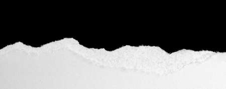 a white piece of paper on a black isolated backgroundの写真素材