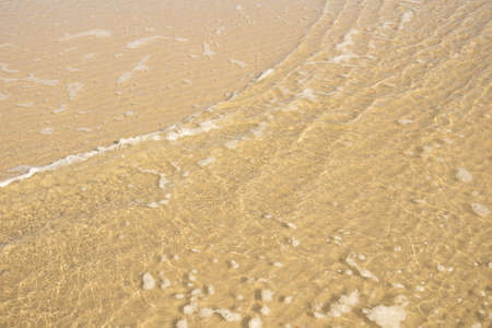 reflection of light in sea water on a background of yellow sand