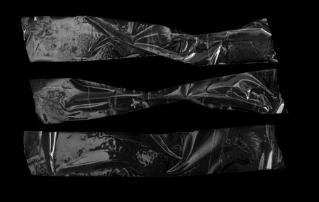 pieces of transparent tape on a black isolated backgroundの写真素材