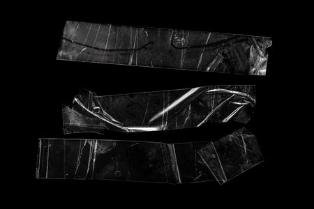 pieces of transparent tape on a black isolated backgrounの写真素材