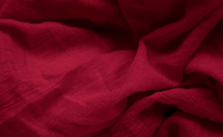 Crinkled red cotton fabric with visible textureの写真素材