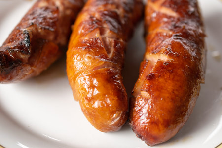 grilled brown sausage on a white plate