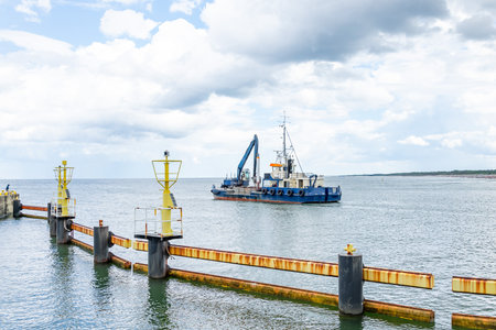 ship with excavator for dredging the entrance to the portの写真素材