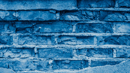 a wall made of old bricks with peeling blue plasterの写真素材