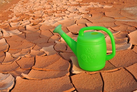 plastic watering can in arid landの写真素材