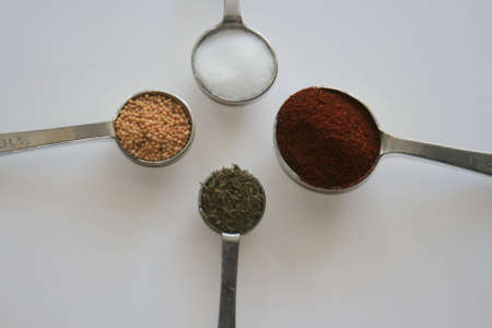 Spices in measuring spoons arranged in a circleの写真素材