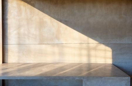 Empty concrete table and shadow of light from window on cement wall.の素材