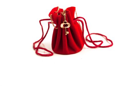 Gold chain with a key on a red small handbagの写真素材