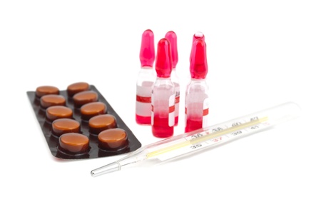 ampoule, a thermometer and pills on a white background