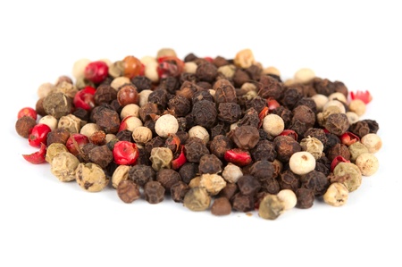 Assorted peppercorns on white background