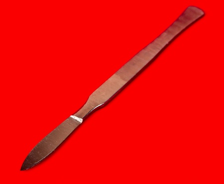 scalpel isolated on red backgroundの写真素材