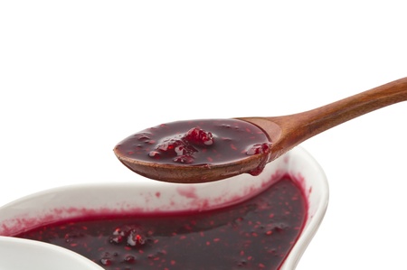 raspberry jam in a wooden spoon isolated on a white background