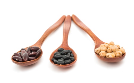 pulses in a wooden spoon isolated on a white backgroundの写真素材