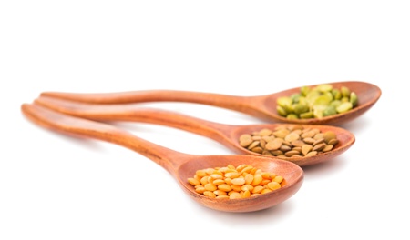 pulses in a wooden spoon isolated on a white backgroundの写真素材