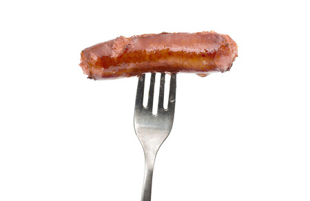 fried sausage on a fork on a white の写真素材
