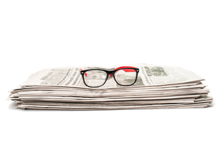 newspaper with glasses closeup on white backgroundの写真素材