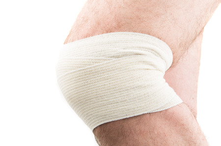 man with elastic bandage on knee, isolated on whiteの写真素材
