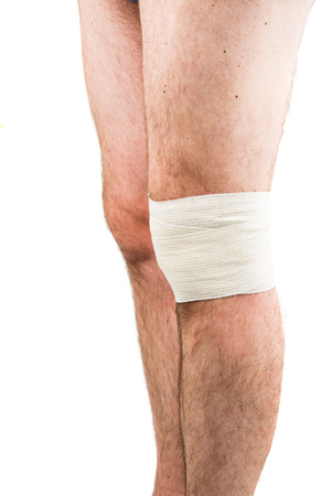 man with elastic bandage on knee, isolated on whiteの写真素材