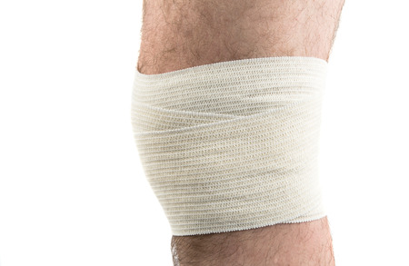 man with elastic bandage on knee, isolated on whiteの写真素材