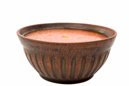 soup in a clay plate on a white backgroundの写真素材