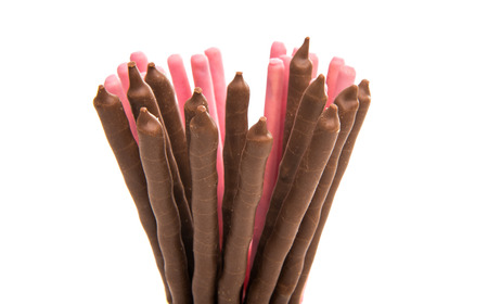 chocolate dipped cookie sticks on white background.の写真素材