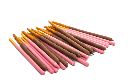 chocolate dipped cookie sticks on white background.の写真素材