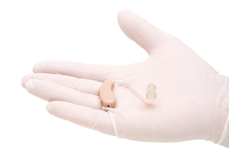 a hearing aid in the doctor's hand on a white backgroundの写真素材