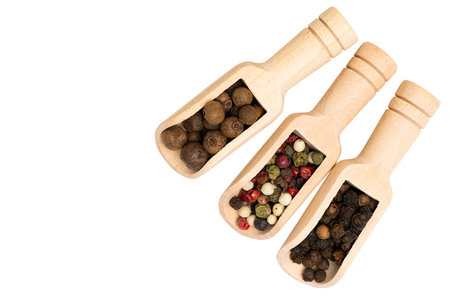 Spices in a wooden spoon isolated on white background