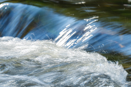 A close-up photo of a river with a small waterfallの写真素材